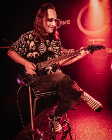 Der Irre an der Gitarre mit einem fiesen grinsen.